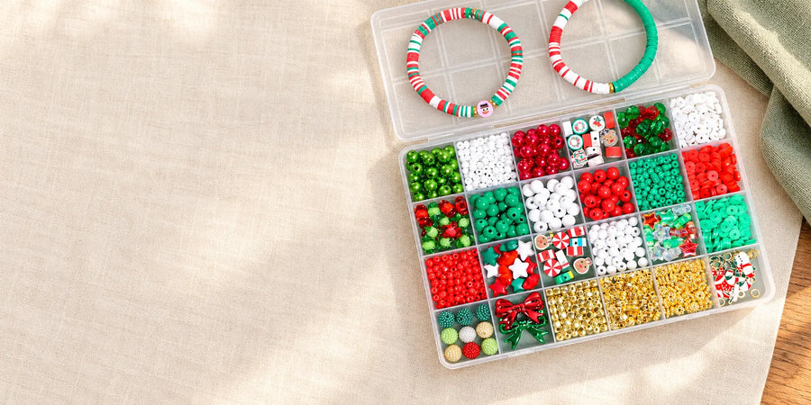 Open organizer of red, green, white and gold beads with two bracelets